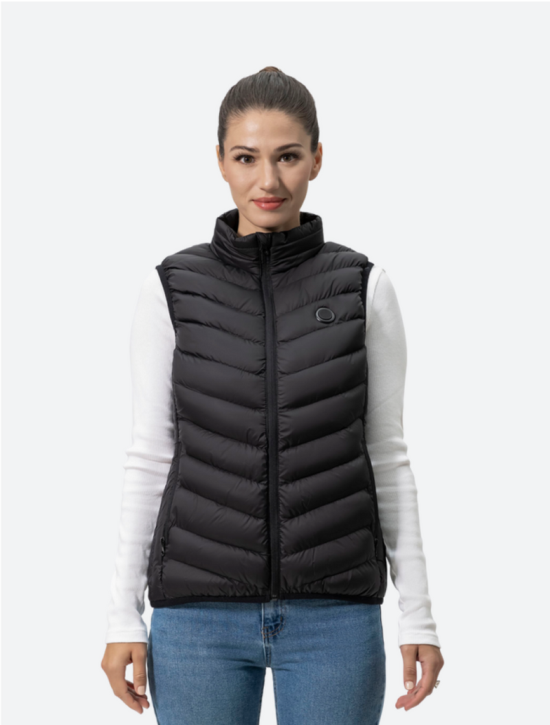 Woman wearing a black puffer vest over a white long-sleeve top, styled with blue jeans against a plain background.