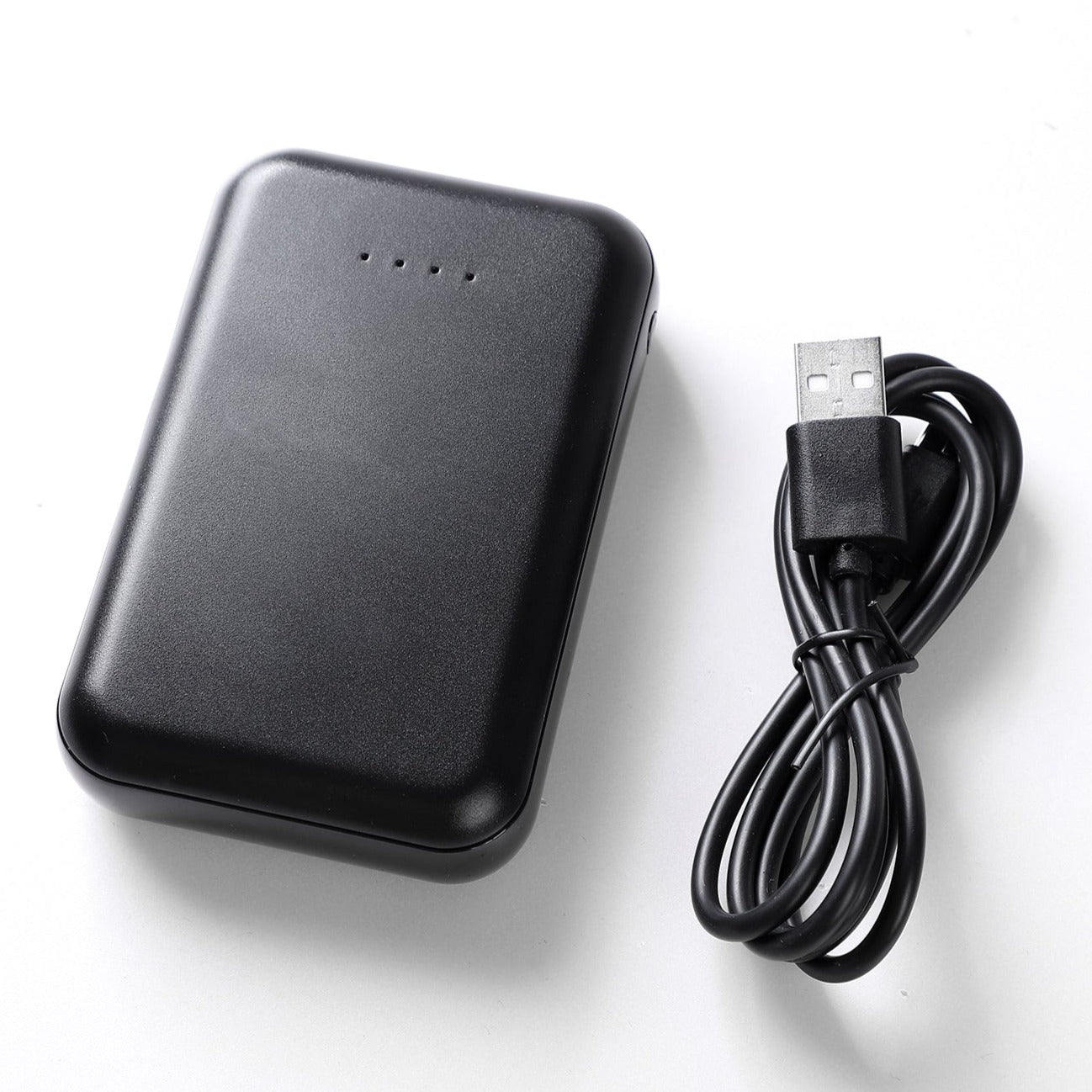 Black portable power bank with USB charging cable on white background.