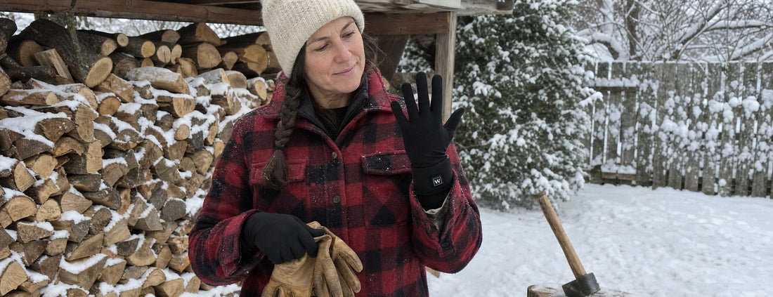 Woman in Weston heated glove liners holding her leather work gloves by a snowy woodpile