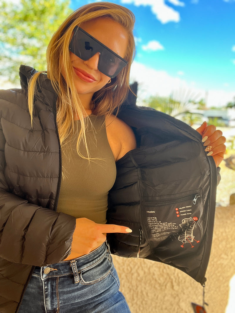 Woman wearing sunglasses displays inside of black jacket with visible instructions and diagrams.