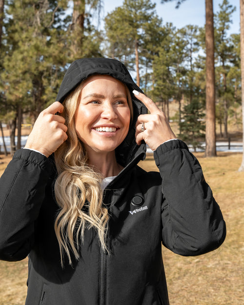 Woman wearing the black Women's Weston Heated Jacket with hood up